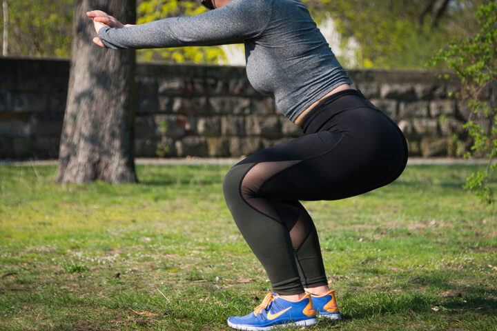 Woman making a squat during the training in the park