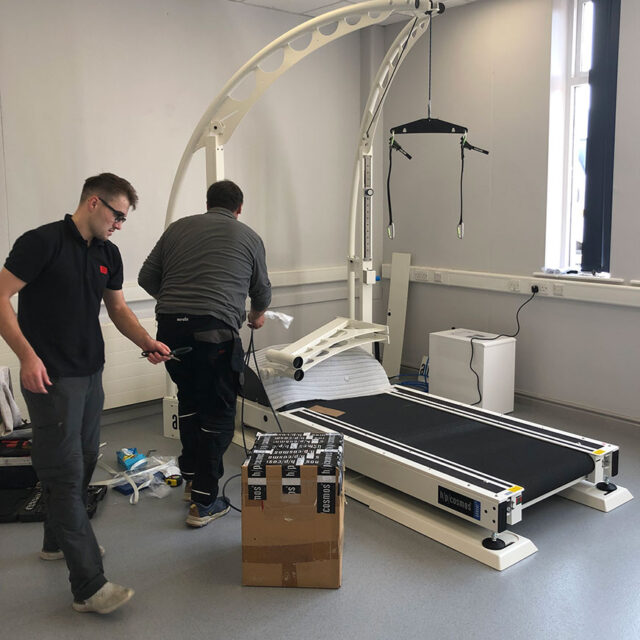 two men installing treadmill