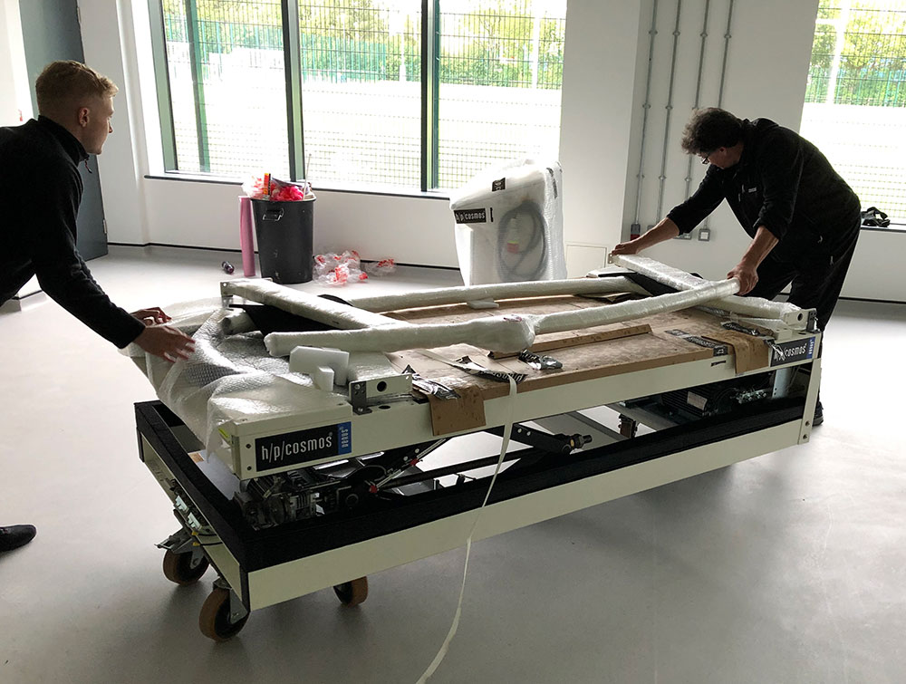 two people installing treadmill