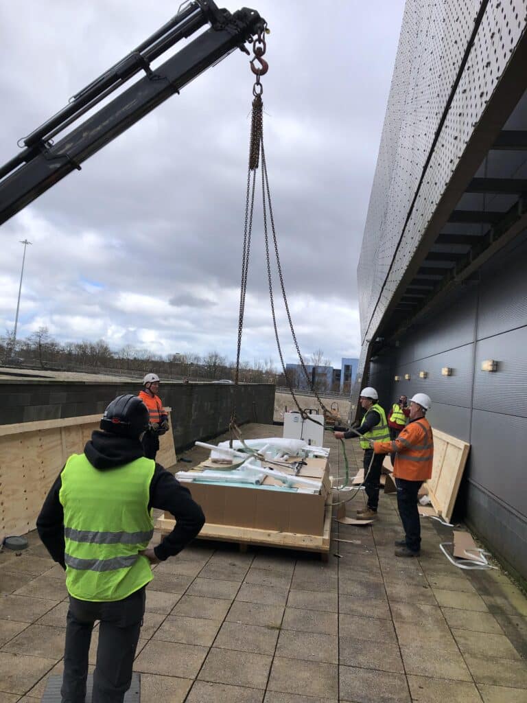 The crane lifting the h/p/cosmos treadmill to the first floor